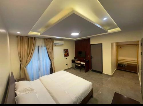 a bedroom with a bed and a desk in it at Degrams Hotel and suites in Epe