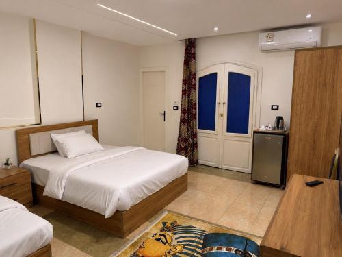 a hotel room with two beds and a table and a room at GREAT PYRAMIDS View lodge in Cairo