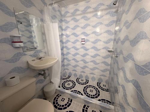 a bathroom with a toilet and a sink at Hotel Hostal Urban18 in Bogotá