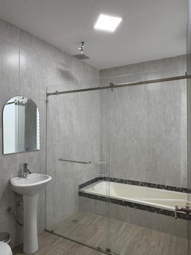 a bathroom with a tub and a sink and a shower at La Posada del Colibrí in Cuenca