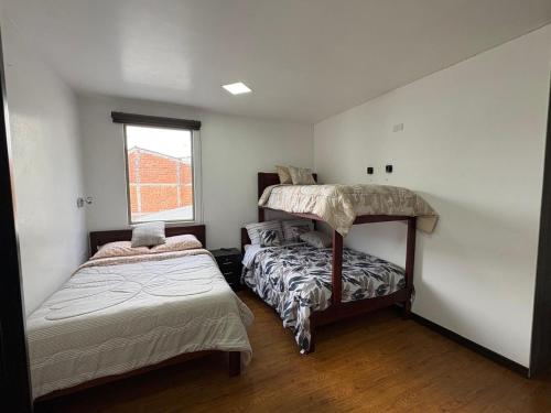 a bedroom with two bunk beds and a window at La Posada del Colibrí in Cuenca