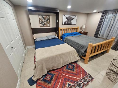 a bedroom with two beds and a rug at The Cottonwood Den in Laramie