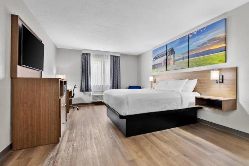 a hotel room with a bed and a flat screen tv at Quality Inn Sheridan in Sheridan
