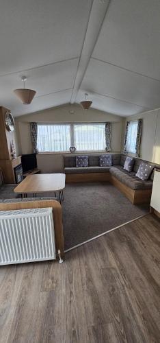 a living room with a couch and a table at South Breeze Caravans in Camber