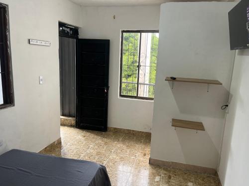 a room with a bed and a window and a door at Hotel Don Franco in Villagarzón