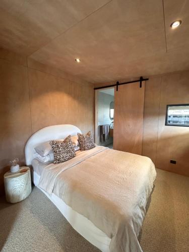 a bedroom with a large bed in a room at Cooks Beach Studio Escape in Cooks Beach