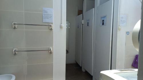 a row of white stalls in a bathroom at casa posada paracas in Paracas