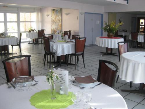 a dining room with white tables and chairs at Domaine de Mont-Evray in Nouan-le-Fuzelier