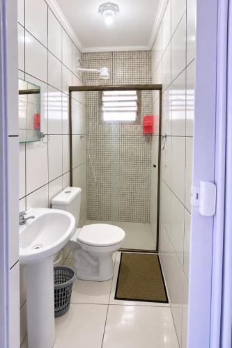 a bathroom with a toilet and a sink and a shower at Apartamentos PraiaMar in Ilha Comprida