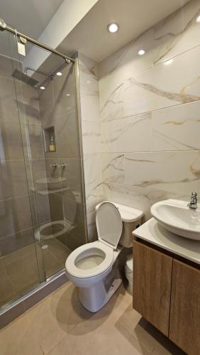 a bathroom with a toilet and a shower and a sink at Apartamento Urban Paipa in Paipa