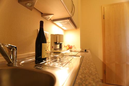a bottle of wine sitting on top of a kitchen sink at Villa Toskana in Bornheim