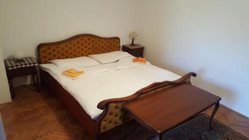 a bed with a wooden headboard and a table at Marinčič Inn in Škocjan