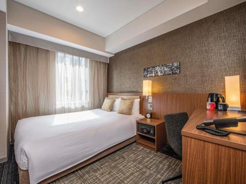 a hotel room with a bed and a desk at ibis Styles Tokyo Ginza in Tokyo