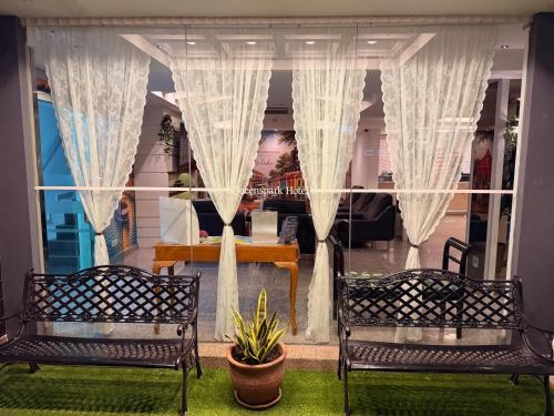 two benches in front of a window with curtains at Royal Queenspark Hotel in Malacca