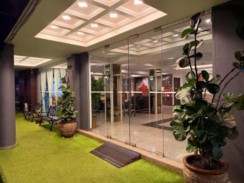an office with glass walls and plants in a room at Royal Queenspark Hotel in Malacca