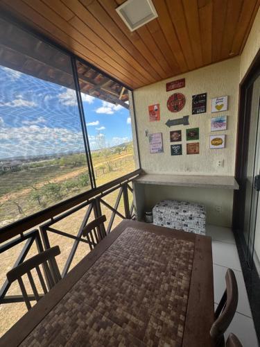 a room with a table and chairs and a large window at Flat com linda vista no Monte Castelo in Sairé