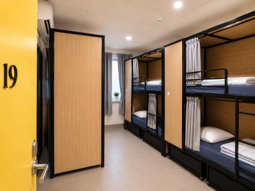 a room with three bunk beds and a door at Perth City Backpackers Hostel - note - Valid passport required to check in in Perth