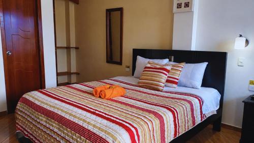 a bed with an orange pumpkin on top of it at Hostal Mariscal Sucre in Tababela