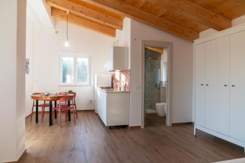 a kitchen with white cabinets and a table in a room at Fili d'Erba Cilento in Villammare