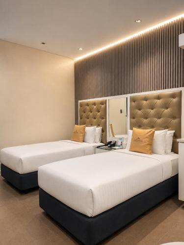 two beds in a hotel room with two bedsvisor at Castle Peak Hotel in Cebu City
