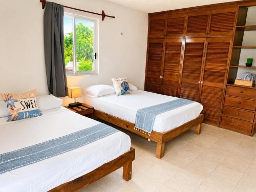 a bedroom with two beds and a window at Aguacatl Cozumel a 3 cuadras del mar in Cozumel