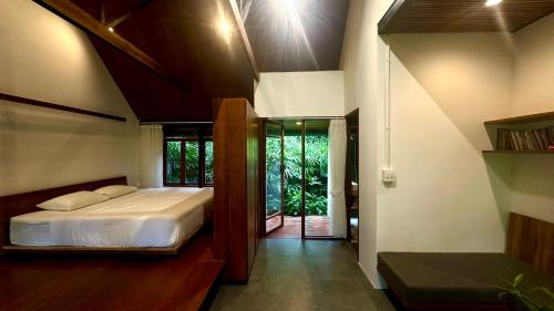 a bedroom with a bed and a glass door at Haven Nest Retreat in Ấp Phú Hòa (3)
