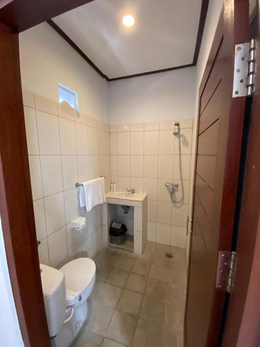 a bathroom with a toilet and a sink at The Lonceng hotel in Badung