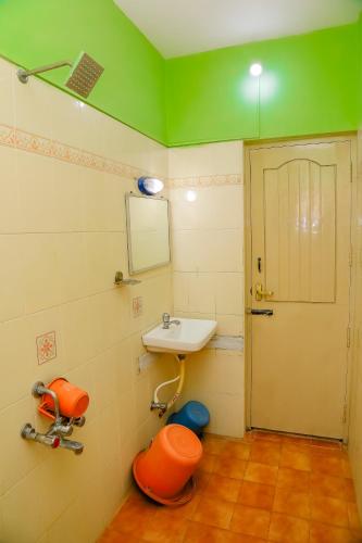 a bathroom with a sink and a toilet and a mirror at Park Palace Inn in Erode