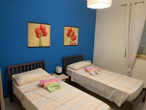 two beds in a room with blue walls at Italian charm, modern elegance in Pizzo in Pizzo