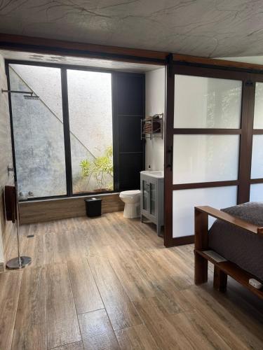 a room with a bed and a bathroom with a window at Farm Suite Bienteveo in Naranjito
