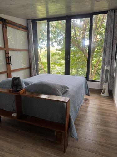 a bedroom with a bed and a large window at Farm Suite San Pedrito in Naranjito