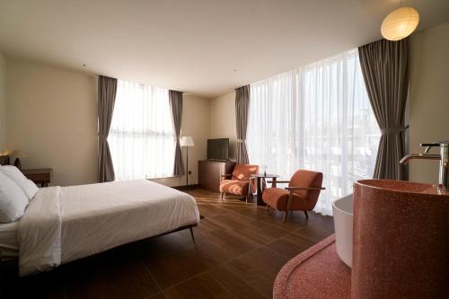 a hotel room with a bed and a chair and a desk at Len Hotel in Da Lat