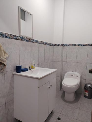ein Badezimmer mit einem weißen Waschbecken und einer Toilette in der Unterkunft Edificio Las Palmas in Tumbes