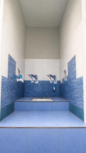 a bathroom with blue tile walls and a sink at Mahadev Guest House in Deoghar