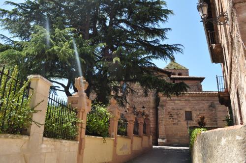 a building with a tree in front of a fence at La Cuculla in Ezcaray