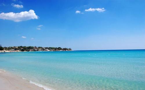 a view of a beach with the blue water at Casa Roby 120 mt Beach in Fontane Bianche