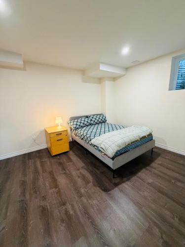 ein Schlafzimmer mit einem Bett und einem gelben Nachttisch in der Unterkunft Niagara Falls 2 Bedrooms 1 and half washroom Luxury Basement Apartment in Thorold