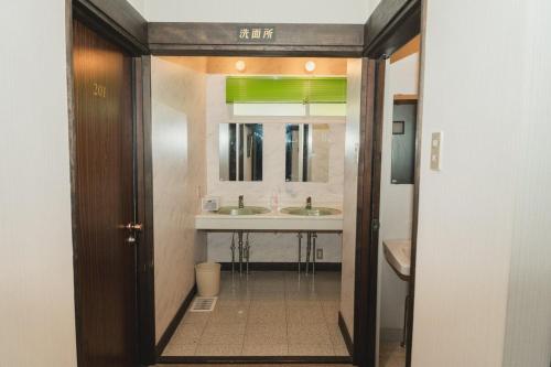 a bathroom with two sinks and a mirror at ラリックス蓼科 in Chino