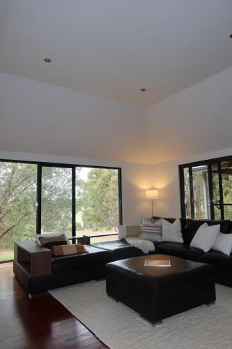 a living room with a black couch and a table at The Siding Yallingup in Yallingup