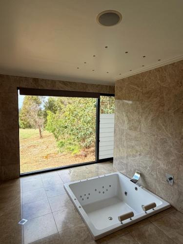a large bath tub in a bathroom with a large window at The Siding Yallingup in Yallingup