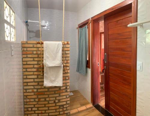 a bathroom with a towel hanging on a brick wall at Casa Verde Canoa Quebrada in Canoa Quebrada