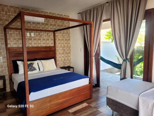 a bedroom with a canopy bed and a balcony at Casa Verde Canoa Quebrada in Canoa Quebrada