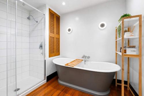 a bathroom with a tub and a shower at The Nelson Loft - Sauna, Balcony & City Centre Living in Nelson