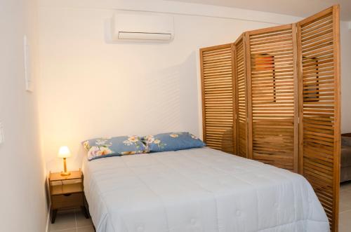 a bedroom with a bed and a wooden closet at Loft Icarai in Niterói