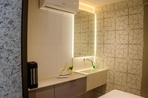 a bathroom with a sink and a mirror at Loft Icarai in Niterói