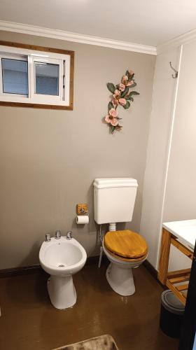 a bathroom with a toilet with a wooden toilet seat at Las Cinco Esquinas in Nueve de Julio
