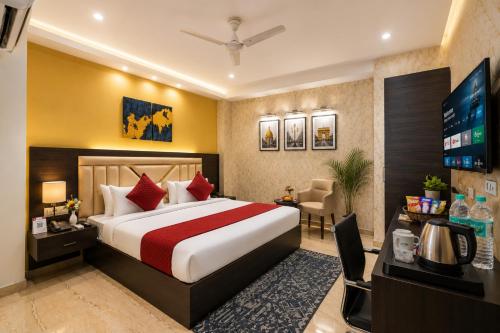 a hotel room with a bed and a desk at The Vanta Luxe Near Yashobhumi in New Delhi