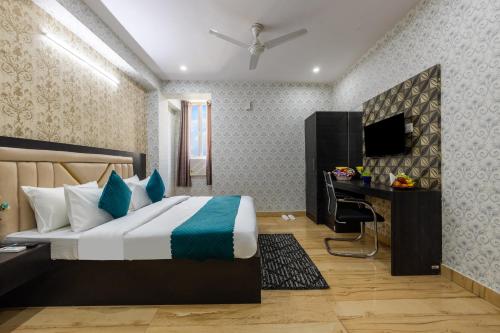 a bedroom with a bed and a desk and a television at The Vanta Luxe Near Yashobhumi in New Delhi