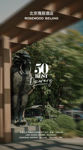 a sign with a lion statue in front of a building at Rosewood Beijing in Beijing