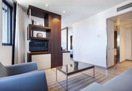 a living room with a couch and a table at Hotel Barcelona Condal Mar, Affiliated by Meliá in Barcelona